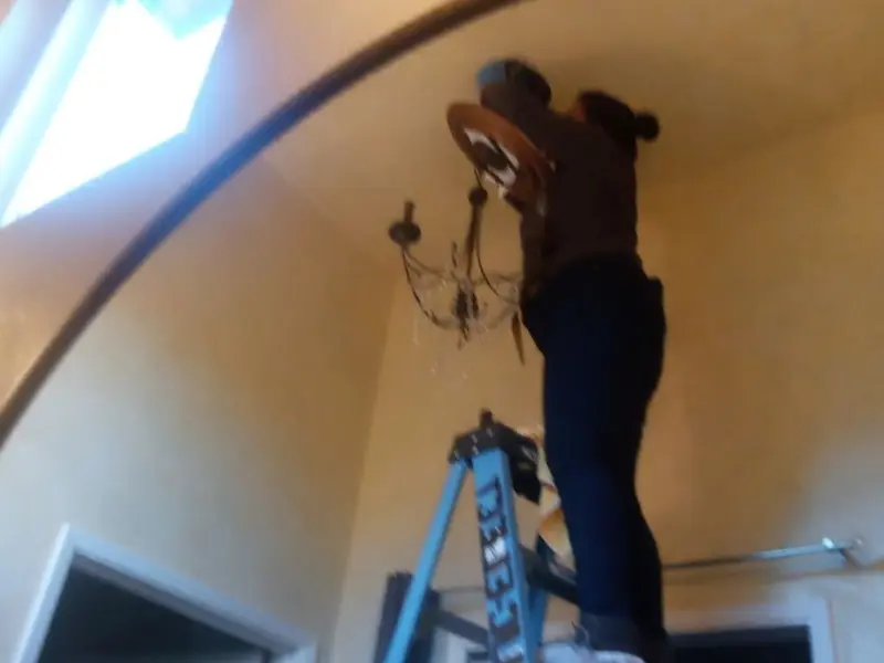 Electrician installing a chandelier in a Moon residence